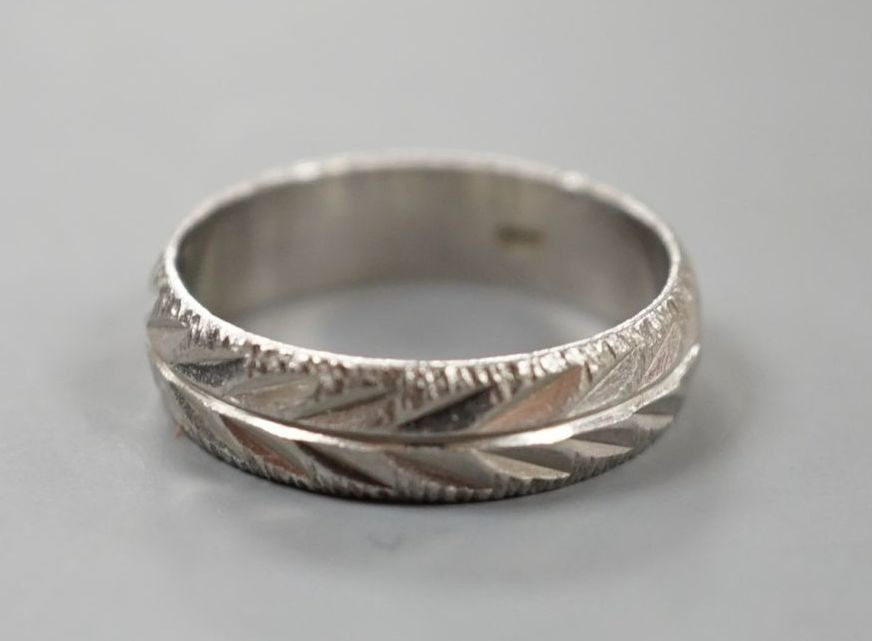A modern bright cut engraved platinum wedding band, size K